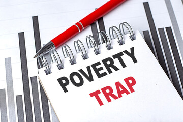 Poverty trap text on spiral notebook with red pen and bar chart background
