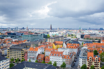 Obraz premium Panoramic view of the center of Copenhagen city in Denmark from the top of the Church of our Savior. Dramatic cloudy sky before raining under the city