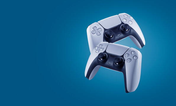2 video game controllers floating in the air on a blue background - copy space