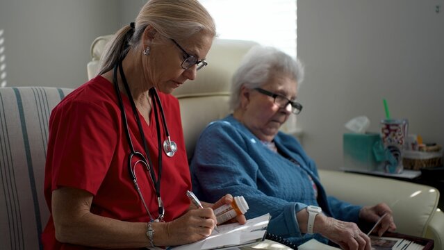 Caregiver attentively assists an elderly woman, promoting interaction and memory care in a comfortable healthcare facility during the day.