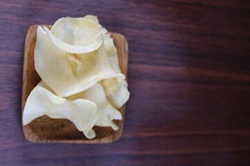 Cassava chips on a rectangular teak wood bowl.