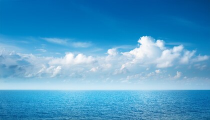 Obraz premium soft hazy blue sky with fluffy clouds over calm blue sea blue photo