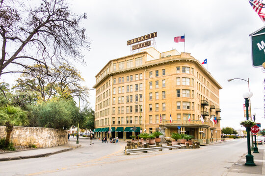 San Antonio, TX - USA: The historic Crockett Hotel in early spring adjacent to Alamo Plaza with American Flag and street scene