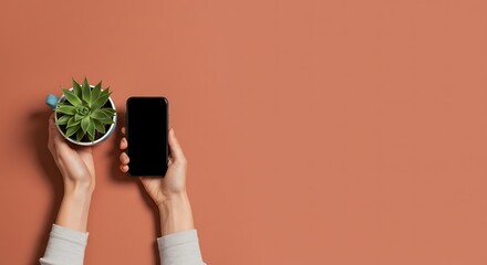 Modern hands: A person holding a plant in a pot and holding a smartphone with a black screen, over a solid background.