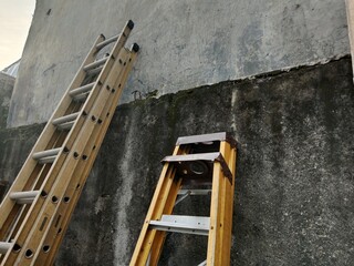 Old Iron Ladder Leaning Against Brick Wall