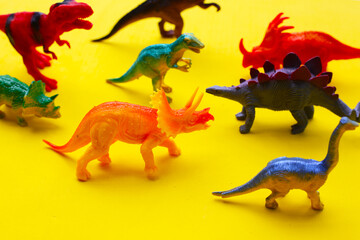 Plastic dinosaur toys on yellow background