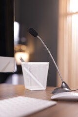 Microphone and computer on wooden desk indoors