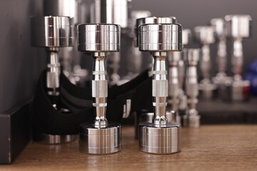Many dumbbells on floor in fitness studio, closeup