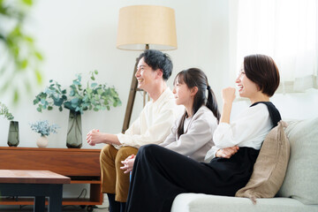 テレビ視聴する3人家族
