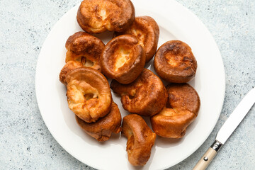 Plate with tasty Yorkshire pudding on light background