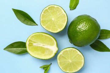 Slices of fresh lime with leaves on blue background
