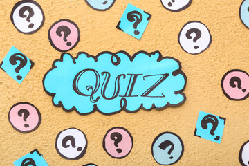 Word QUIZ in speech bubble with question marks on orange background