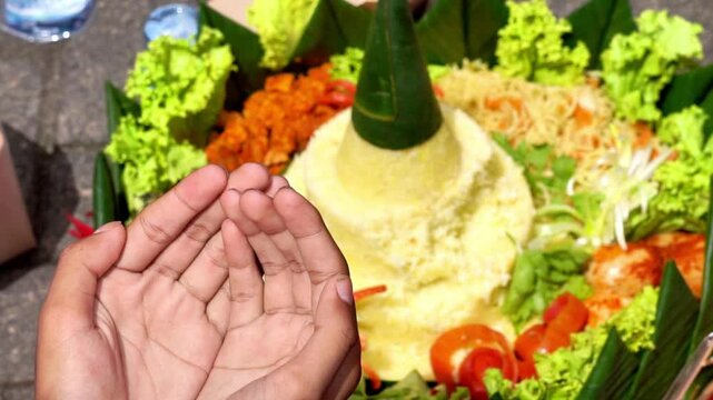 Hands taking nasi tumpeng. Nasi tumpeng is rice that is usually served at thanksgiving or certain event.