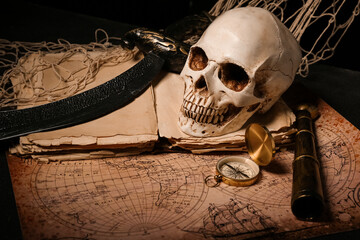 Human skull with sword, old manuscripts, world map and compass on black background