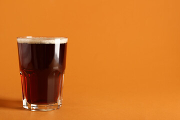 Glass of tasty kvass on orange background