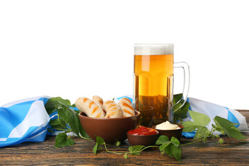 Mug with cold beer, sausages, sauces and flag of Bavaria on table against white background. Oktoberfest celebration