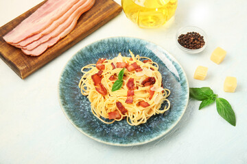 Plate with tasty pasta carbonara and ingredients on white background