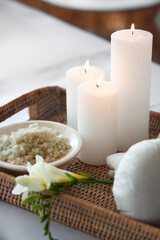 Spa composition with burning candles on couch in salon, closeup