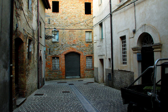COMUNANZA, ITALY - AUGUST 14, 2022: Streets of Comunanza. A vintage Ape car rests on a shaded, mysterious street in Comunanza&rsquo;s old town, where history and charm intertwine quietly