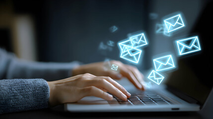 Hands Typing On Laptop Keyboard With Glowing Email Icons In Dark Blurred Background