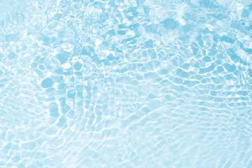 Blue water with ripples on the surface. Defocus blurred transparent blue colored clear calm water surface texture with splashes and bubbles. Water waves with shining pattern texture background.