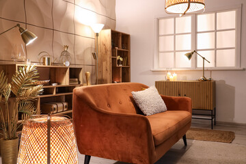 Interior of stylish living room with glowing lamps and sofa at night