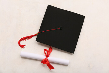 Diploma with red ribbon and graduation hat on white background