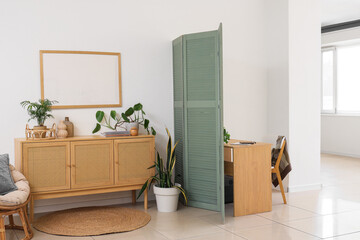 Interior of living room with folding screen and workplace
