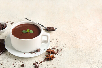 Cup of hot chocolate with mint leaves on white grunge background