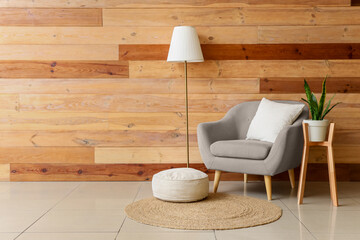 Interior of stylish living room with grey armchair, standard lamp and houseplant