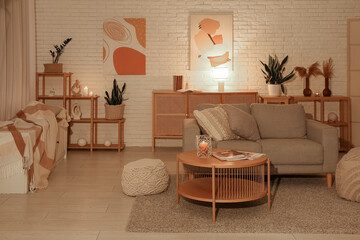 Cozy sofa, coffee table and glowing lamps in interior of living room