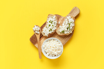 Bowl with fresh cottage cheese and bread slices on yellow background