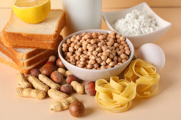 Different products on beige table, closeup. Food Allergy Awareness Month