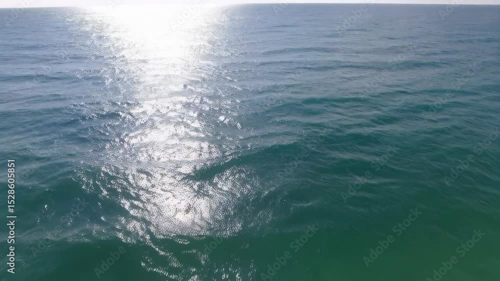 Poster open ocean water ripples in the bright sunlight, creating glimmering reflections and abstract patter