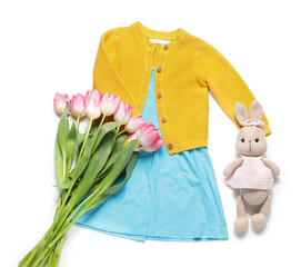 Little girl spring outfit with bunny toy and tulips on white background