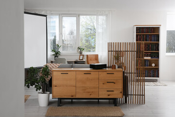 Interior of room with video projector, folding screen and bookshelf