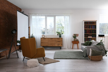 Interior of room with video projector, sofa and armchair