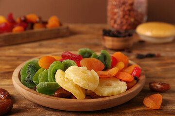Tray with different dried fruits on wooden table, closeup