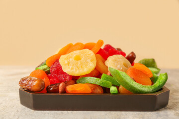 Tray with different dried fruits on grey grunge table, closeup