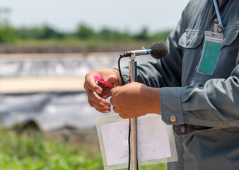 The environmental officer is installing a noise monitoring sign at the measurement point.