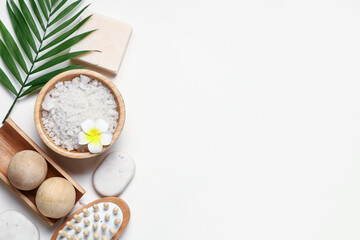 Obraz na płótnie Canvas Composition with bowl of sea salt, spa accessories and palm leaf on light background