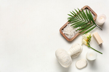 Composition with spa accessories, burning candles and palm leaf on light background