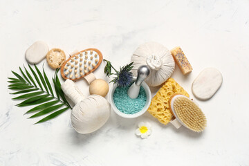 Obraz na płótnie Canvas Composition with sea salt, different spa accessories and palm leaf on light background
