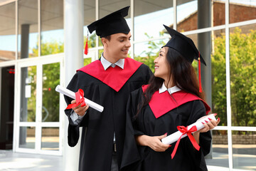 Couple of students with diplomas on their graduation day