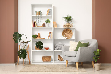 Interior of room with shelf unit, armchair and plants