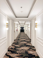 Elegant White Corridor with Wall Sconces and Floral Pattern Carpet