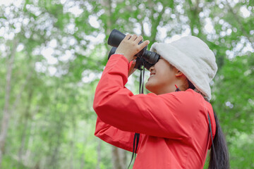 Study trip student girl holding binoculars looking green forest