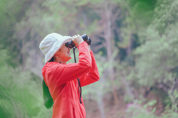 Study trip student girl holding binoculars looking green forest
