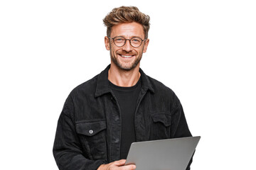 A man wearing glasses and a black jacket is smiling and holding a laptop