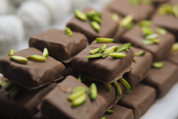 Chocolate confections topped with green nuts on display